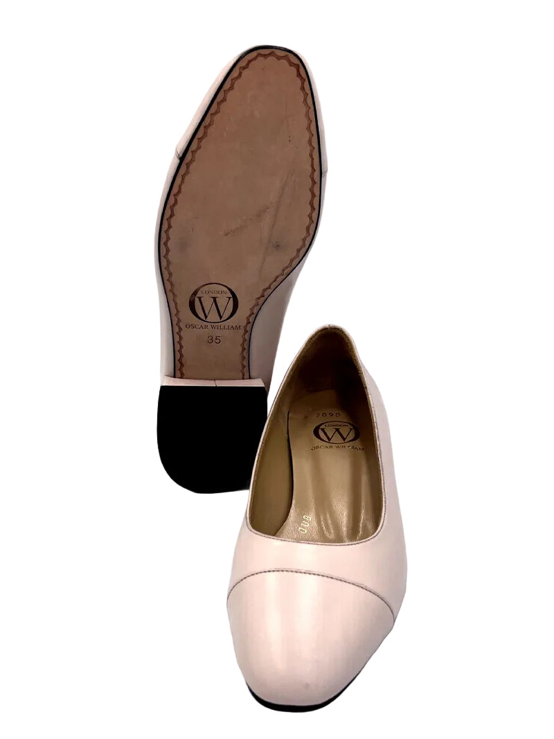 Light pink shoe with brown insole on a white background