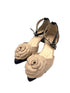 Beige high-heeled shoes with floral design on a white background