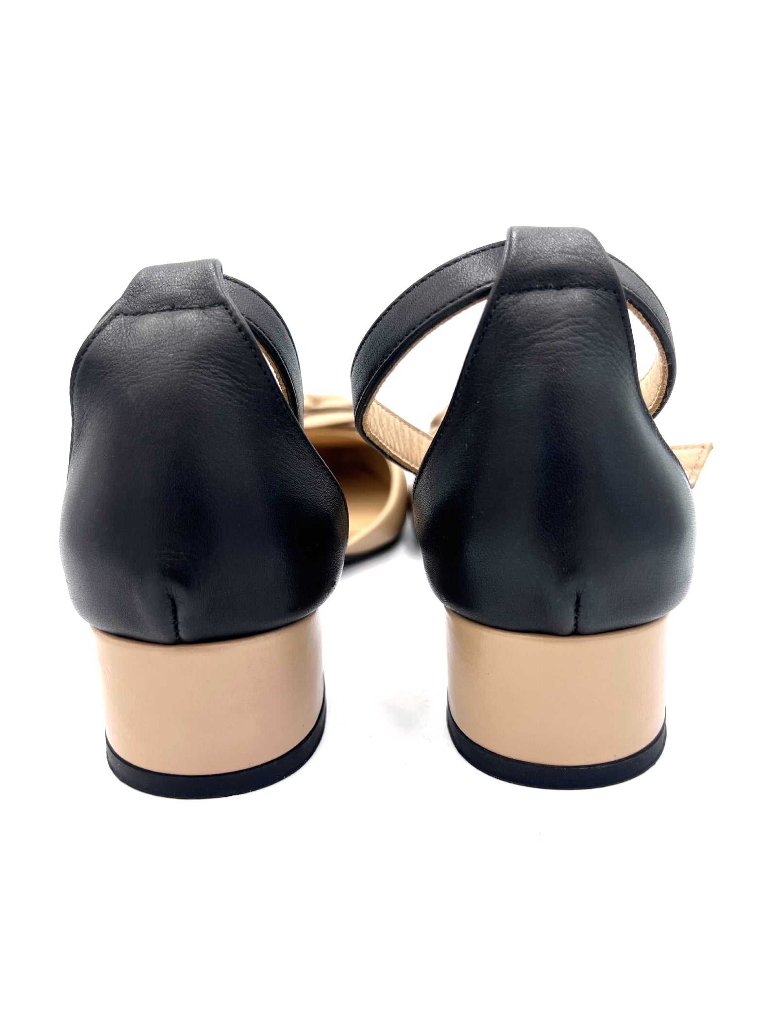 Black high-heeled shoes with beige soles on a white background
