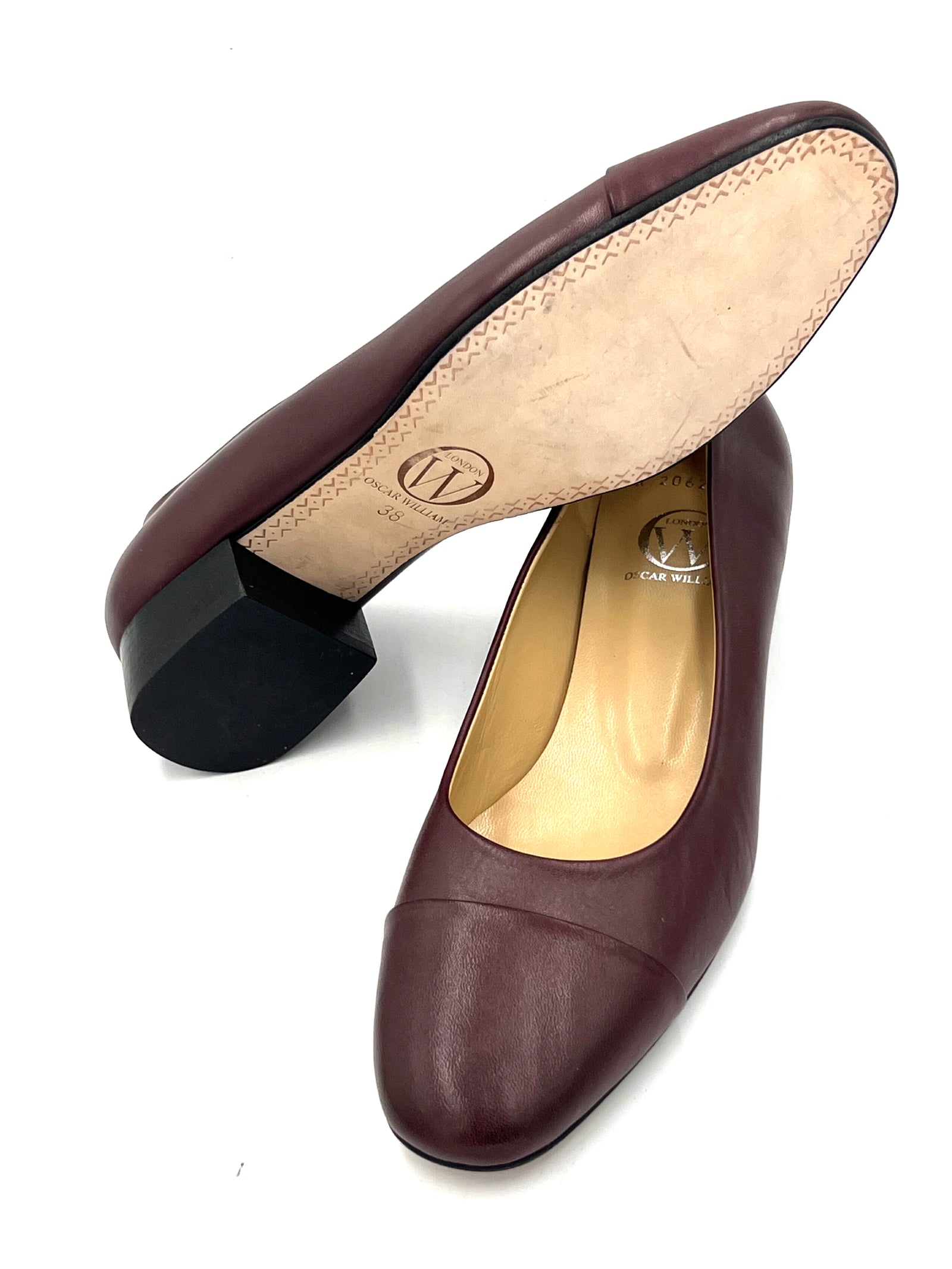 Pair of maroon high-heeled shoes on a white background
