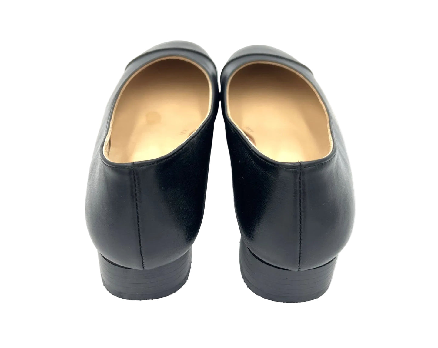 Pair of black shoes with beige soles on a white background