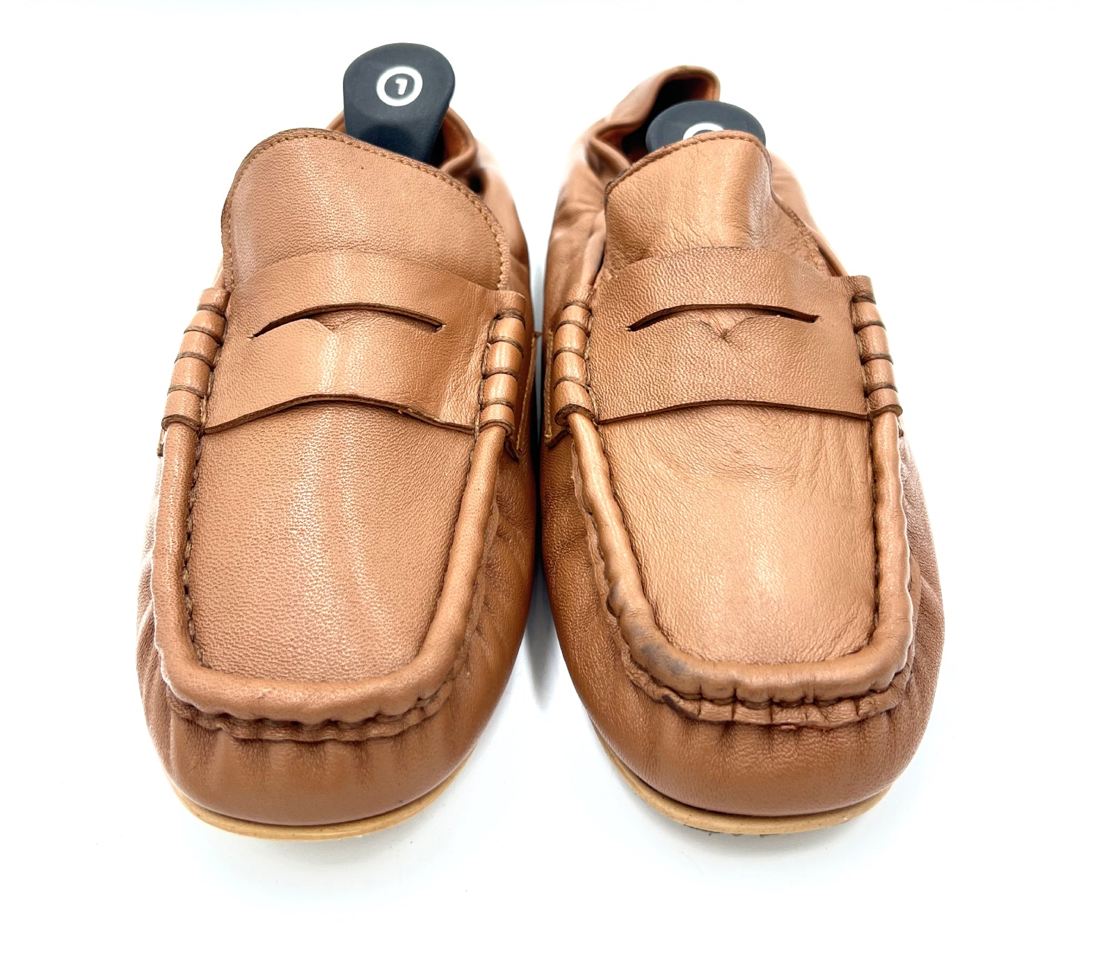 Pair of tan loafers on a white background