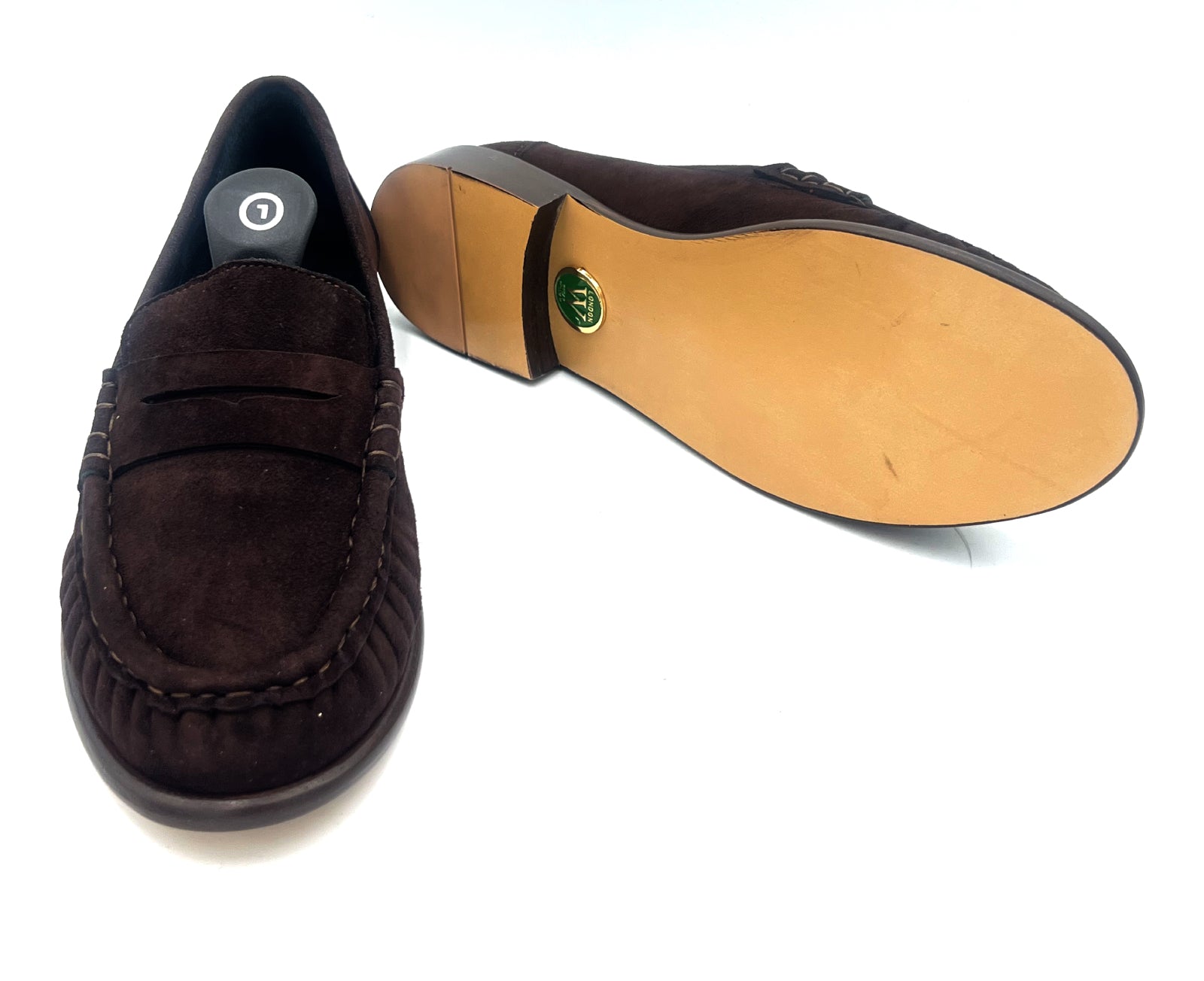Brown suede loafers with a tan sole on a white background