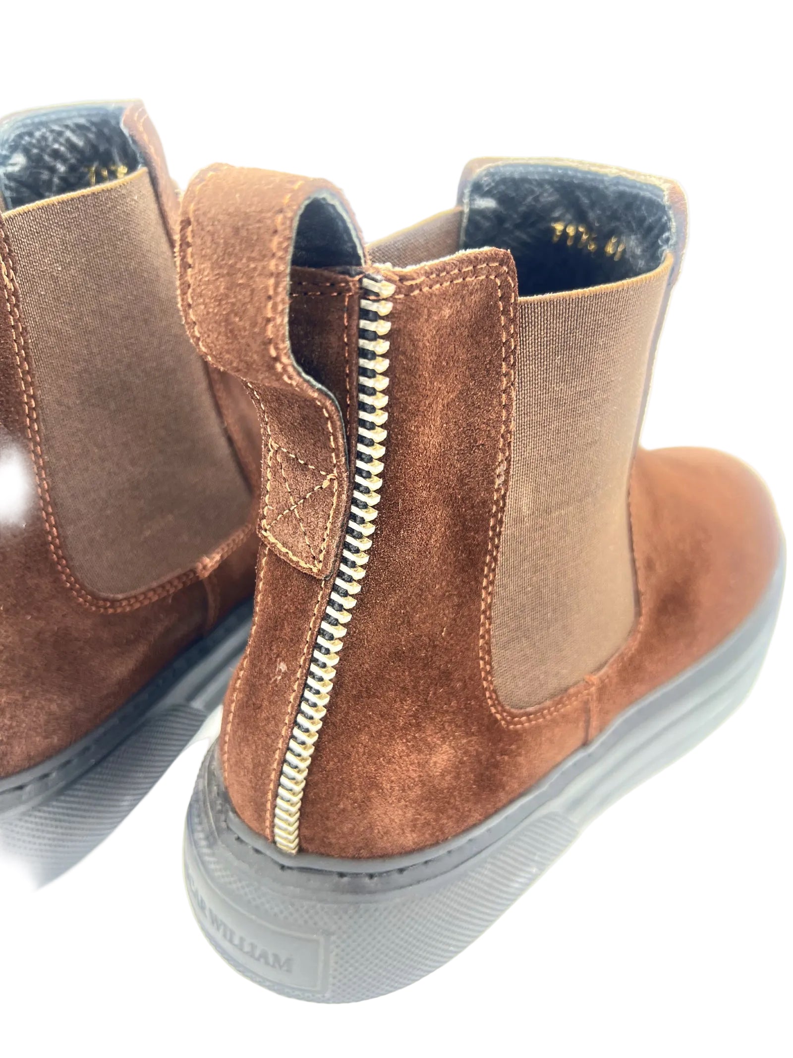 Brown suede boots with a zipper on a white background
