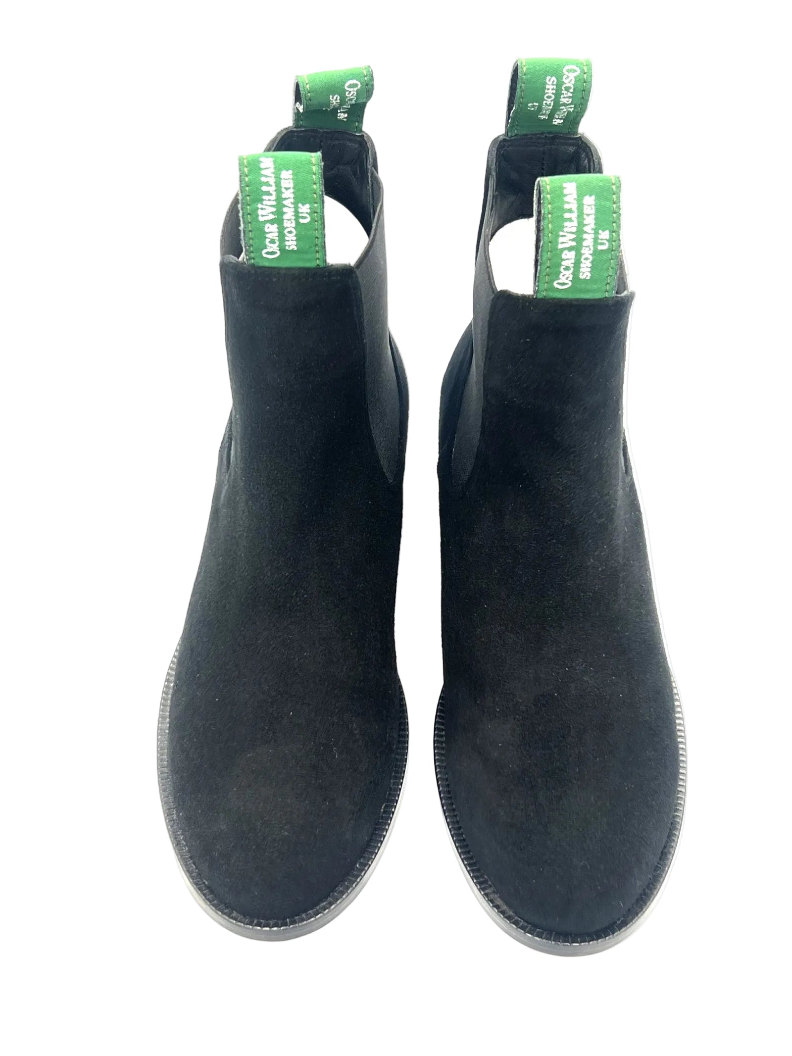 Pair of black boots with green tags on a white background