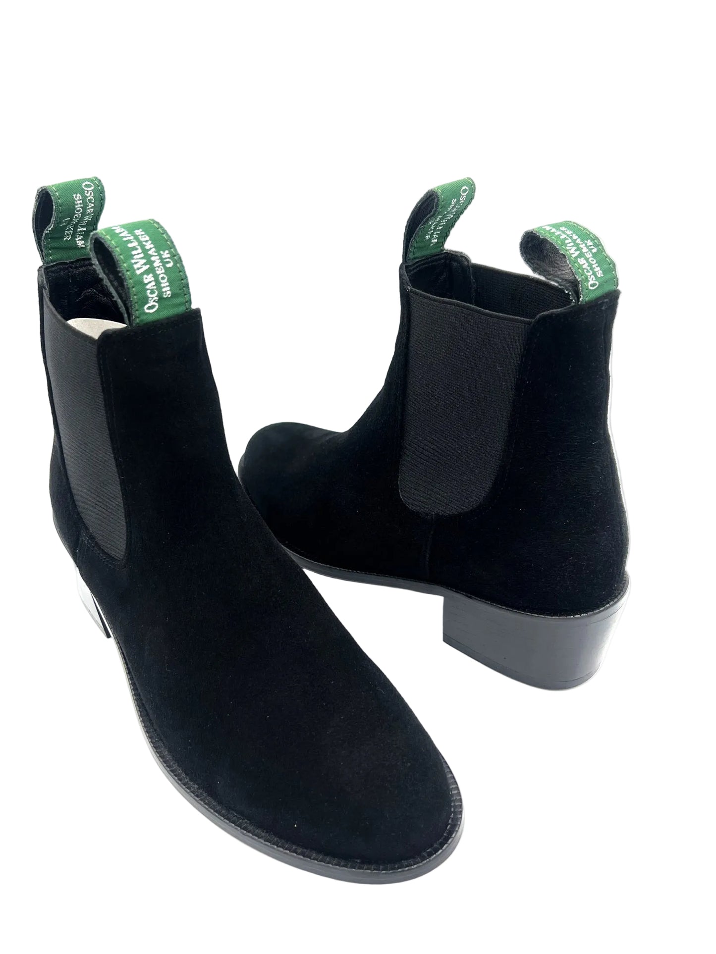 Black ankle boots with green tags on a white background
